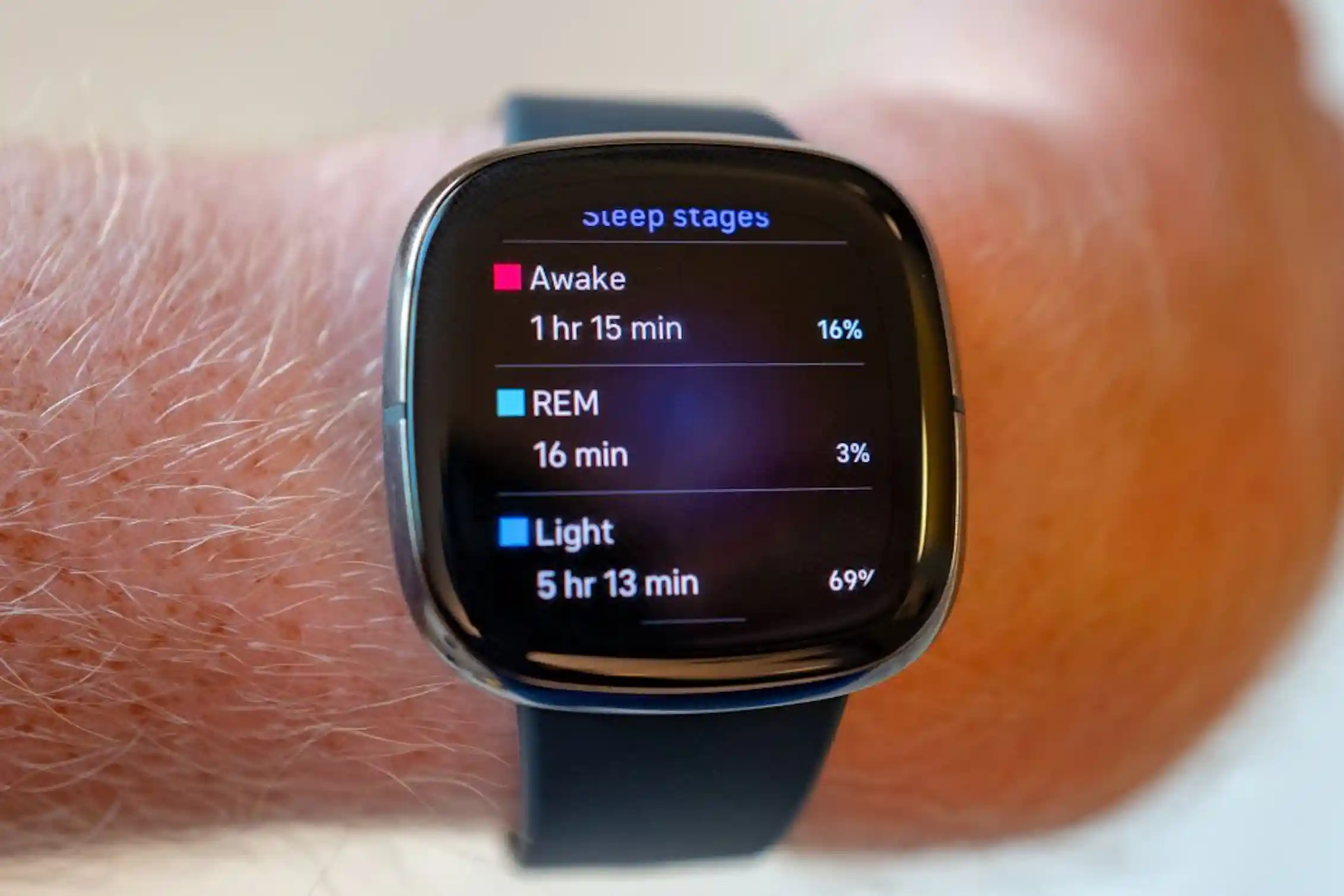 A wrist with a sleep tracking device showing a sleep score.