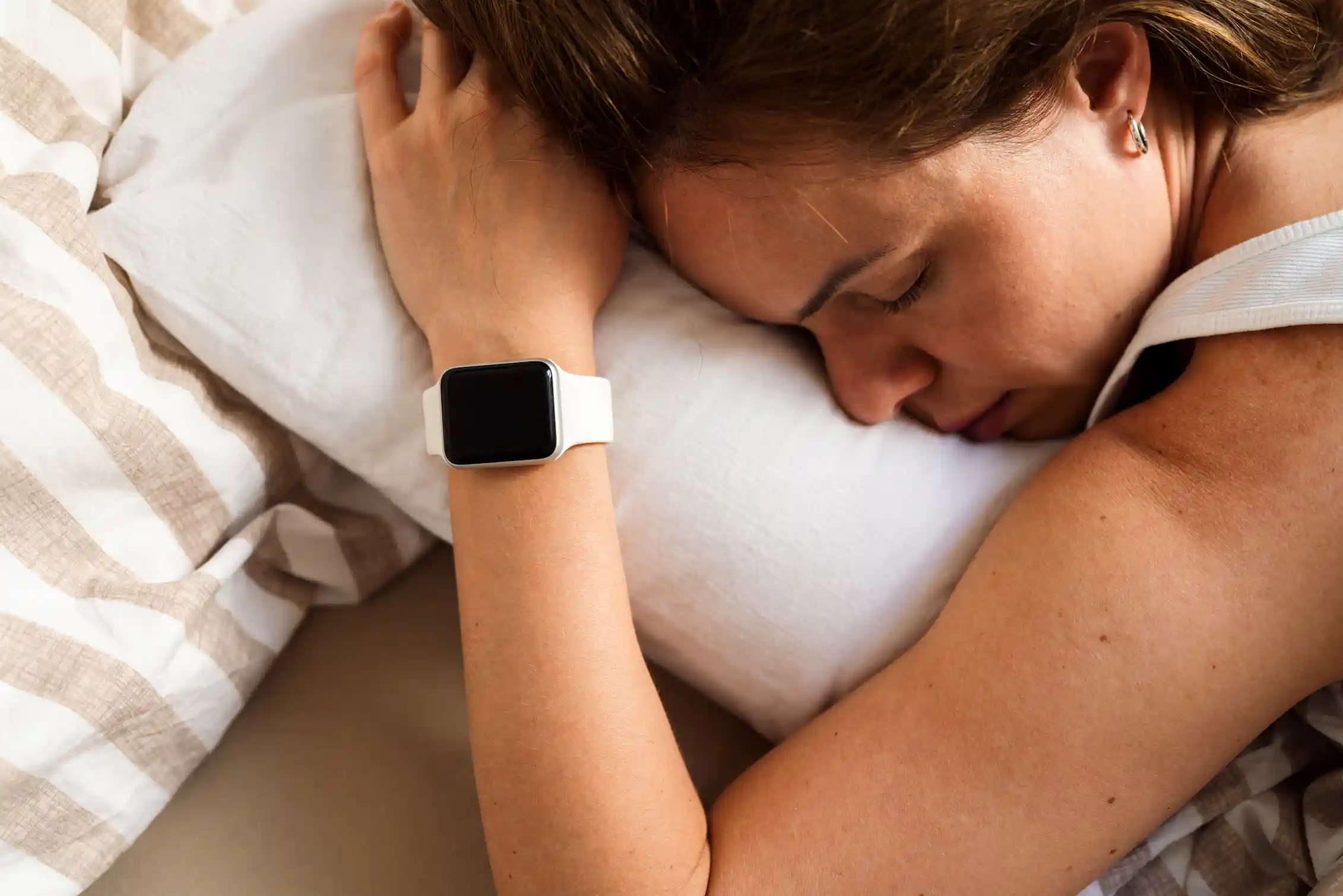 Woman asleep with smartwatch on wrist.