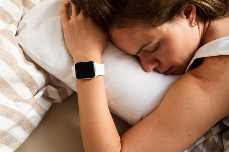 Woman asleep with smartwatch on wrist.