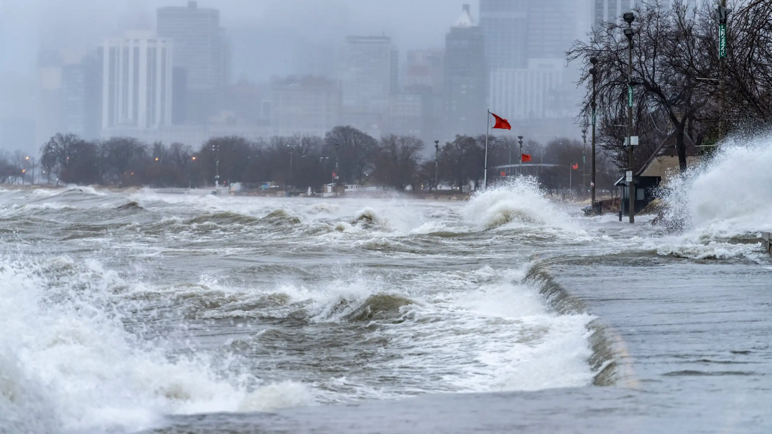Waves crash against the shore of a flooded beach