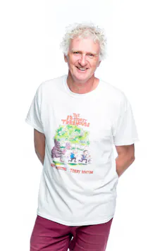 Terry Denton, a tall man with grey curly hair, smiling, wearing a t-shirt that advertises The 13-Storey Treehouse