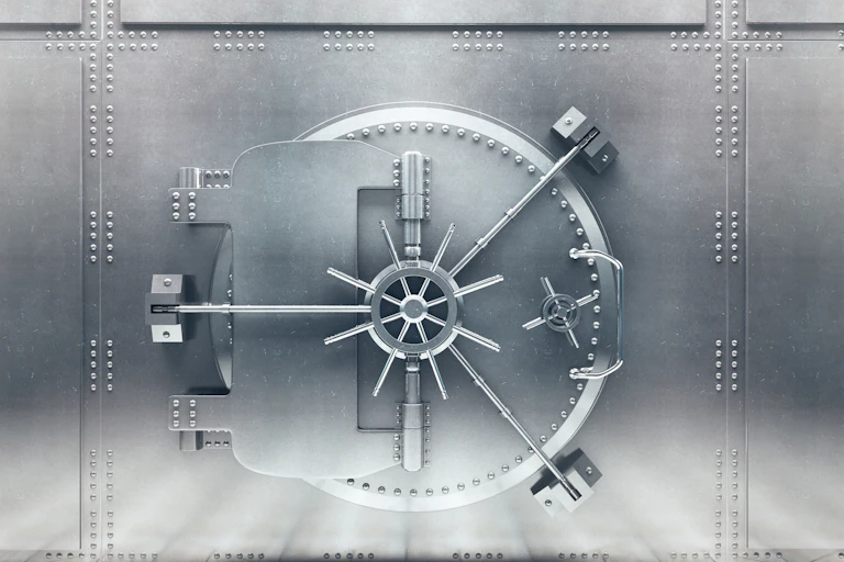 A steel vault door in high contrast lighting.