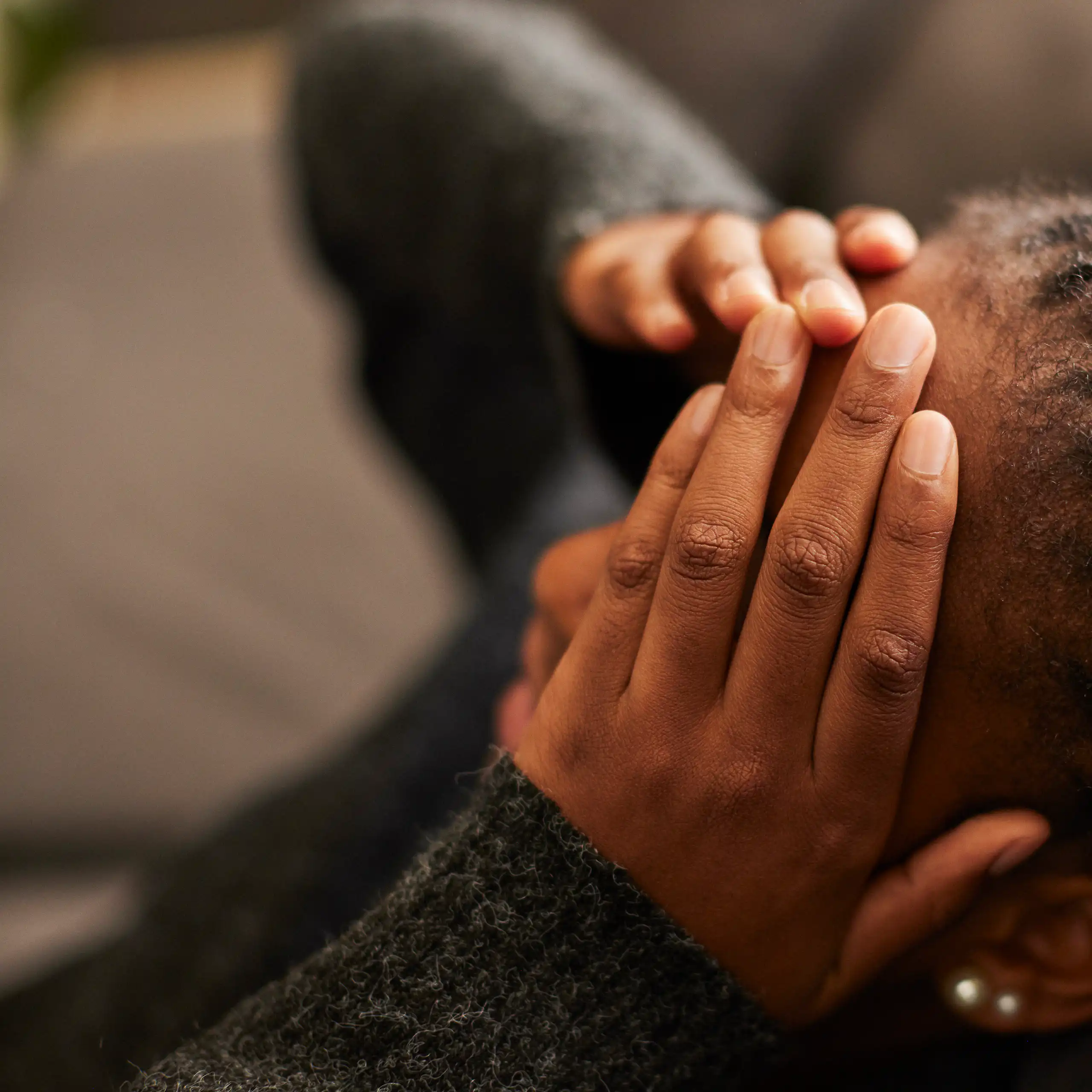 A teen girl puts her hands on her forehead