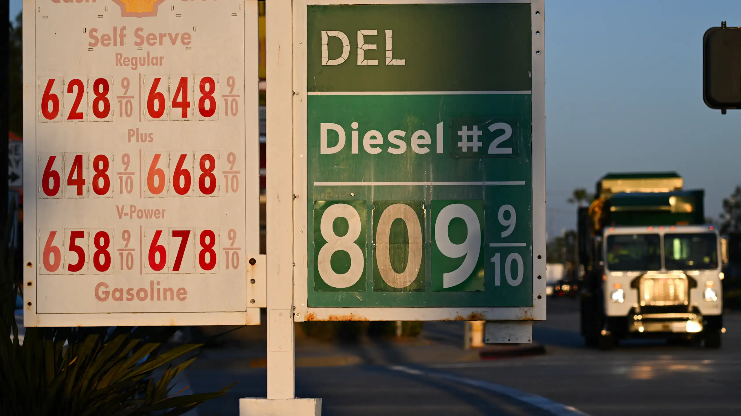 A garbage truck drives past gas prices above $6 a gallon and diesel prices above $8 a gallon as they are displayed outside of a Shell gas station in Carson, California on September 22, 2026.