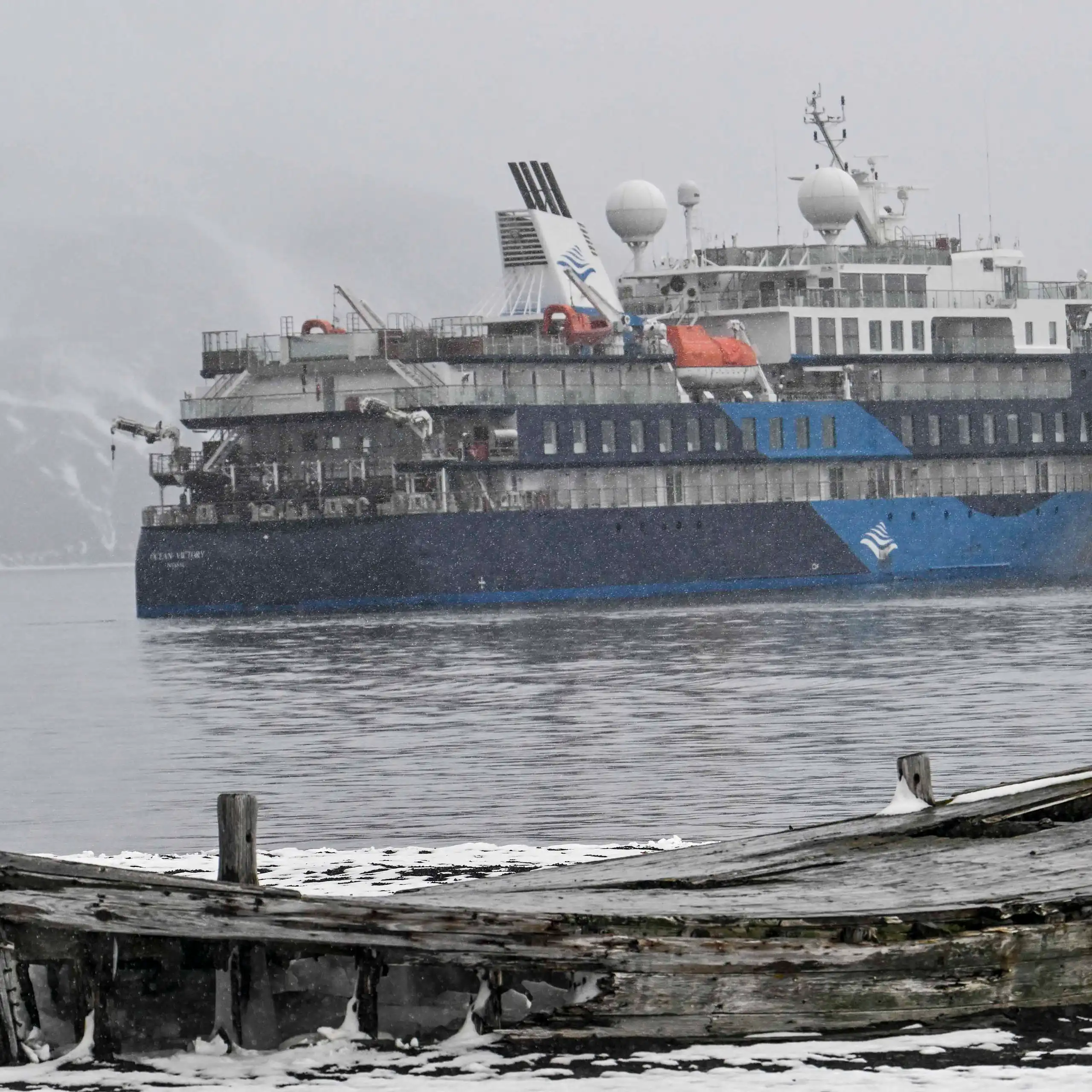 L’« Ocean Victory » au second plan. Au premier plan, un vieux bateau en bois abandonné sur la banquise.