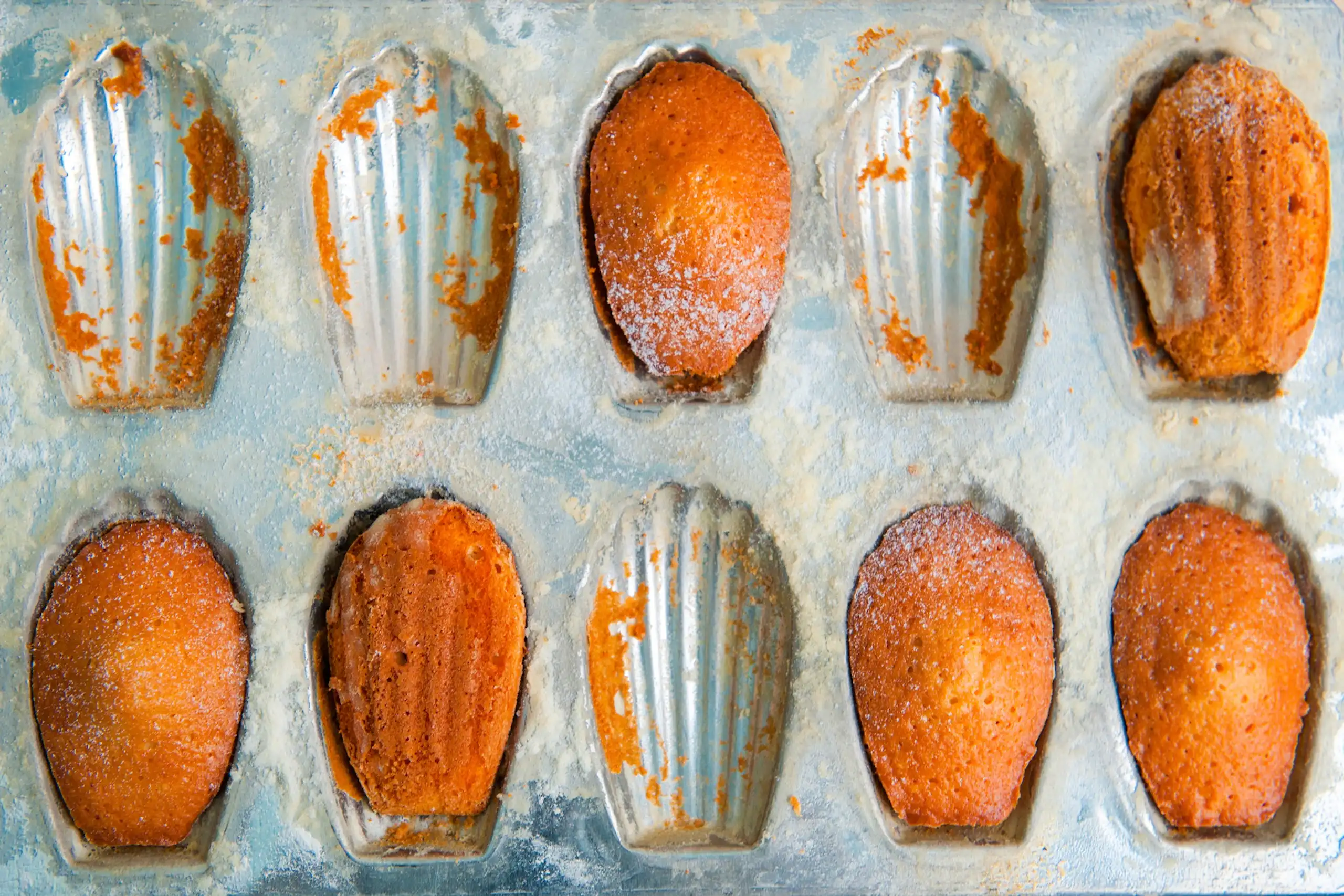 Moule de madeleines cuites, mangées pour certaines.