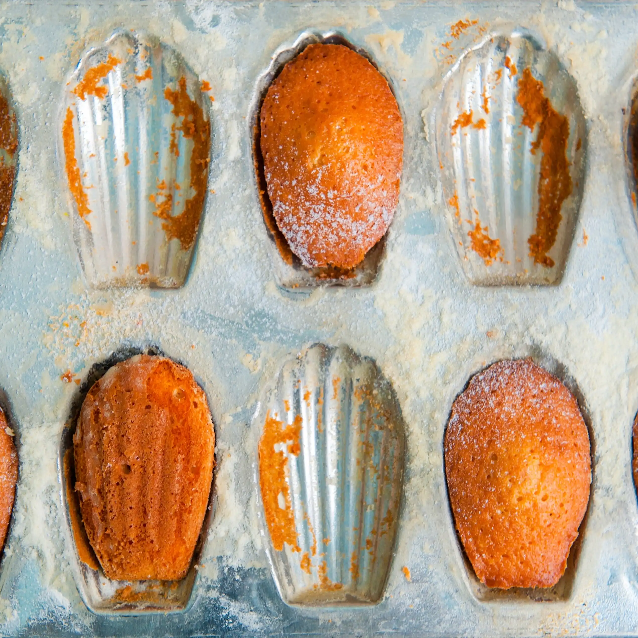Moule de madeleines cuites, mangées pour certaines.