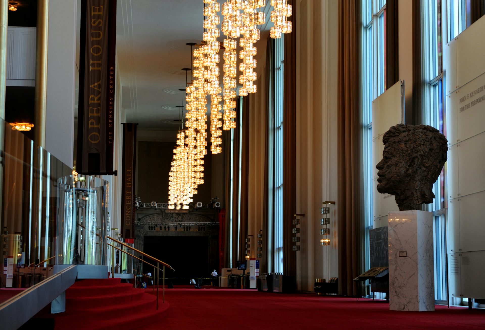 A bust of John F. Kennedy looks out over an expanse of red carpet.