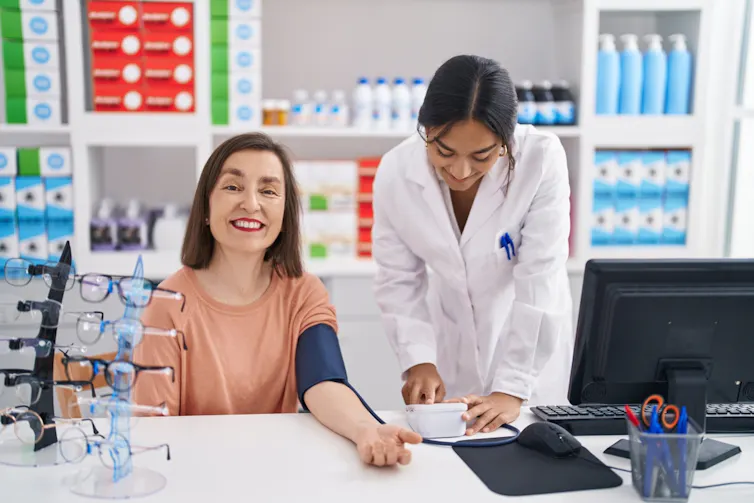A woman having her blood pressure checked at a pharmacy.