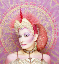Fashion designer Zandra Rhodes dressed in a shiny pink and gold outfit.