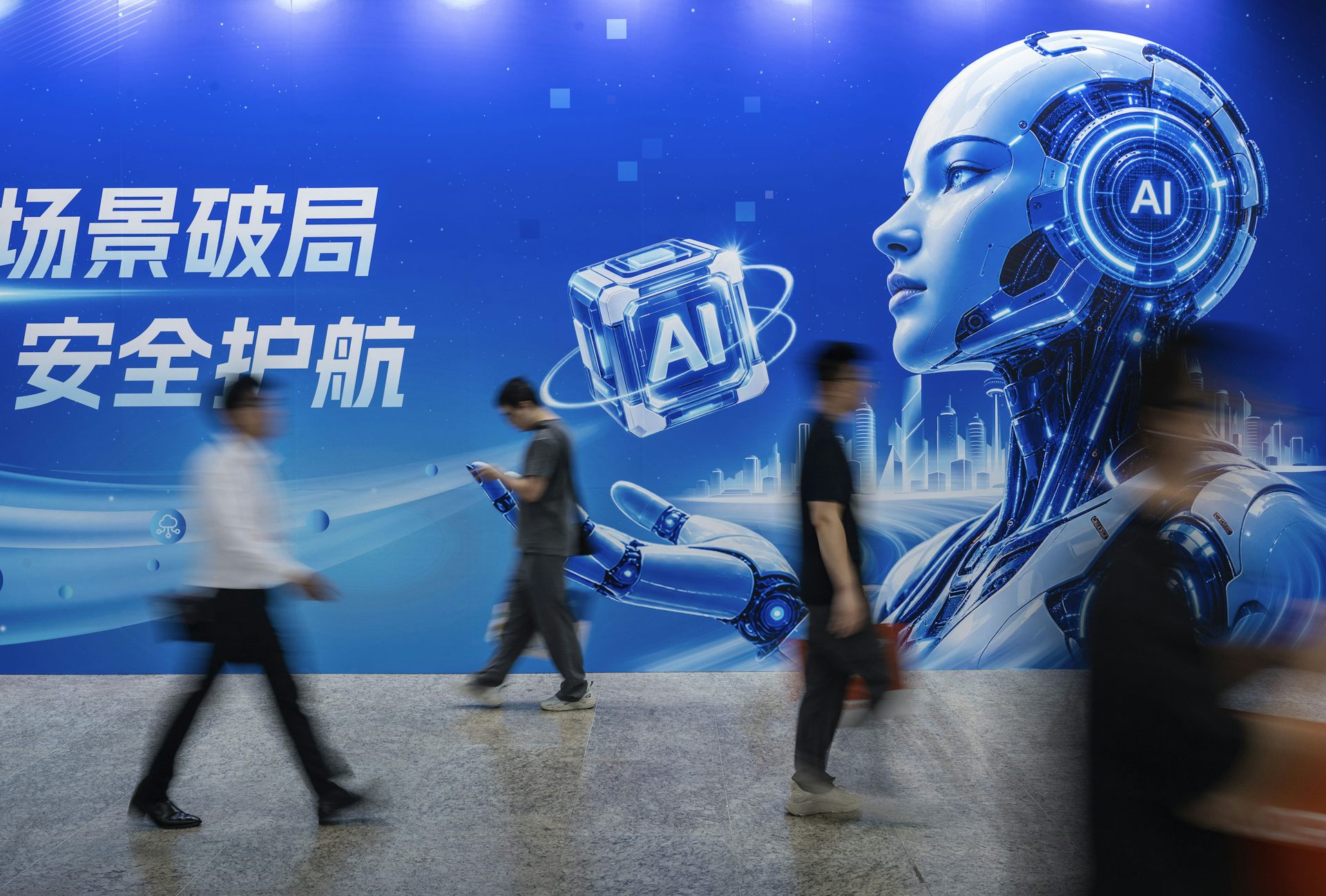 Several people walk by a billboard and a robot depicted on it.