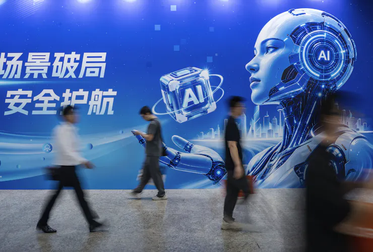 Several people walk by a billboard and a robot depicted on it.