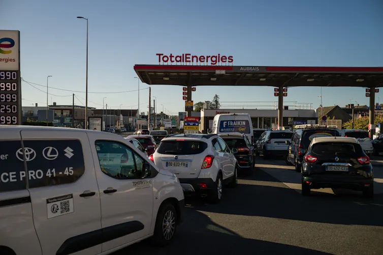 Cars line up at a gas station.
