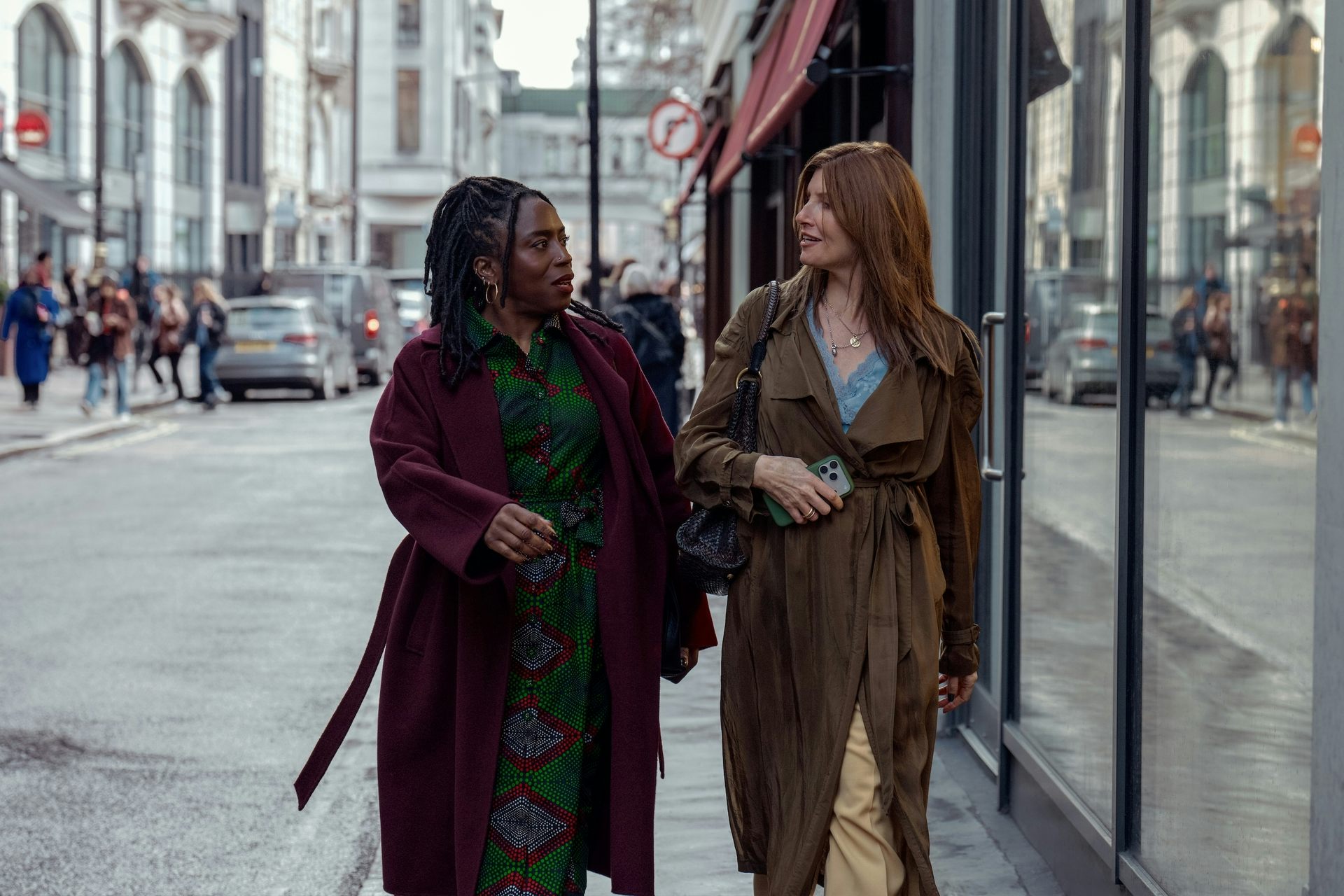 Two women walking down the street arm in arm