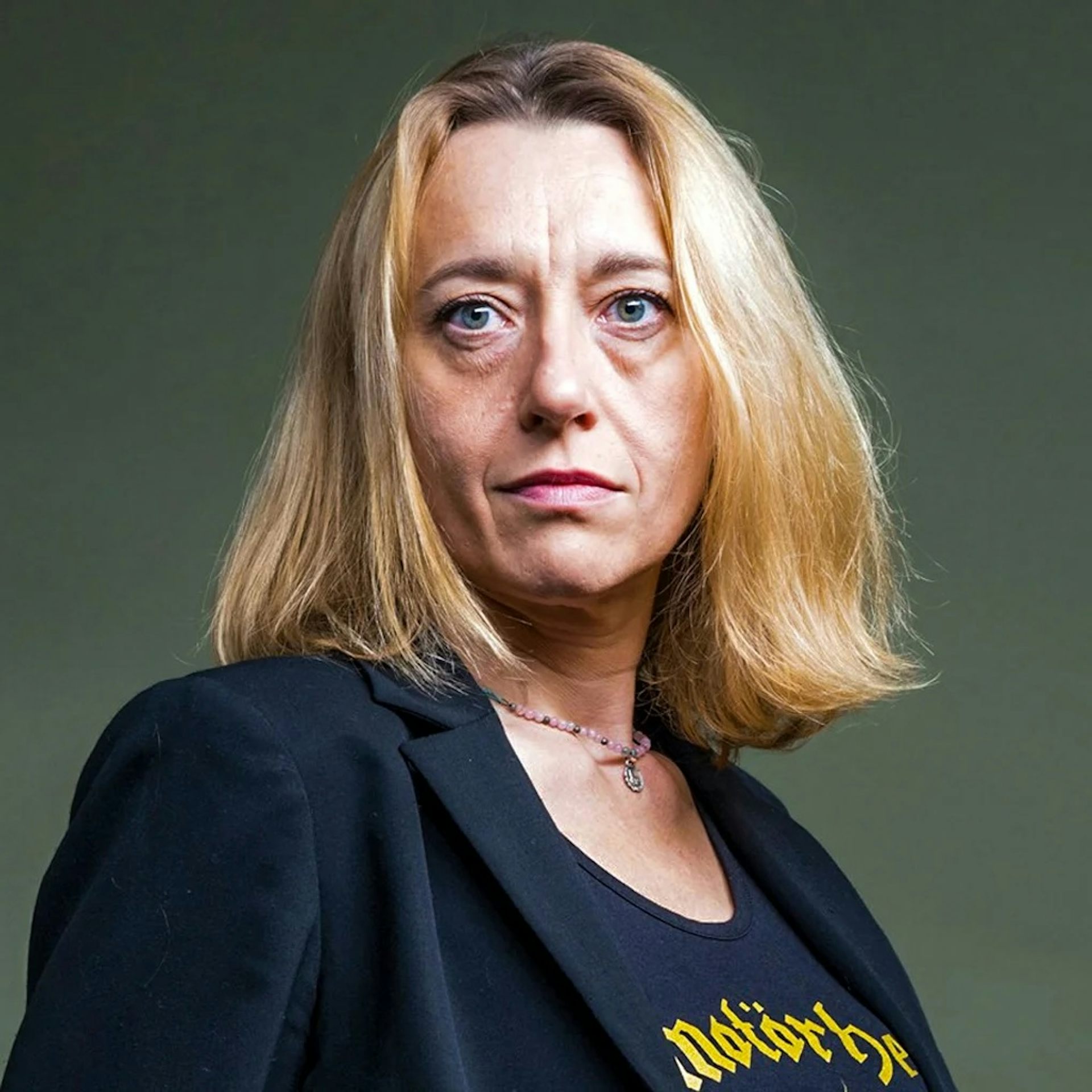 A woman with blonde hair, a black blazer and a t-shirt