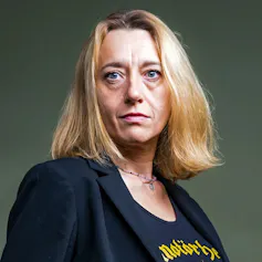 A woman with blonde hair, a black blazer and a t-shirt