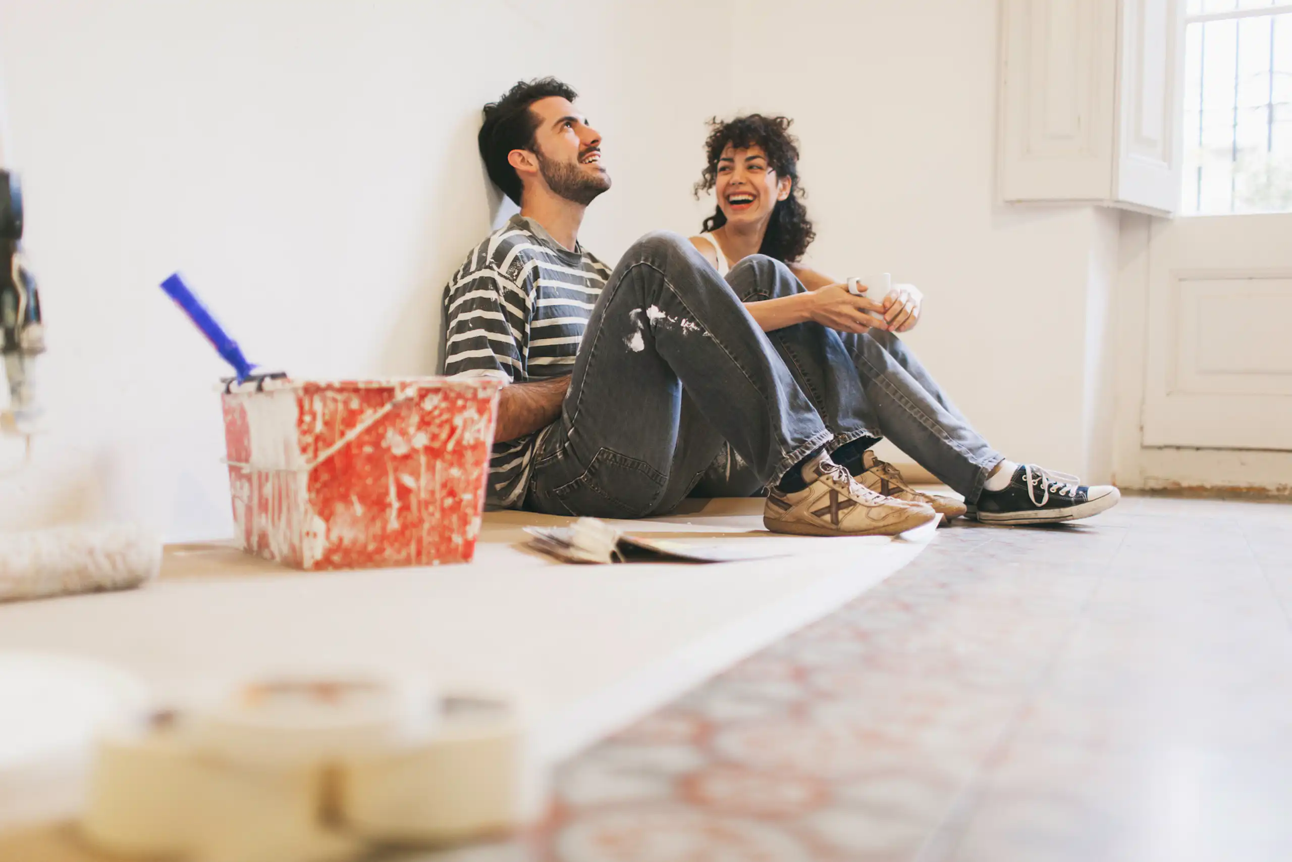 A couple rests between bouts of painting their apartment.