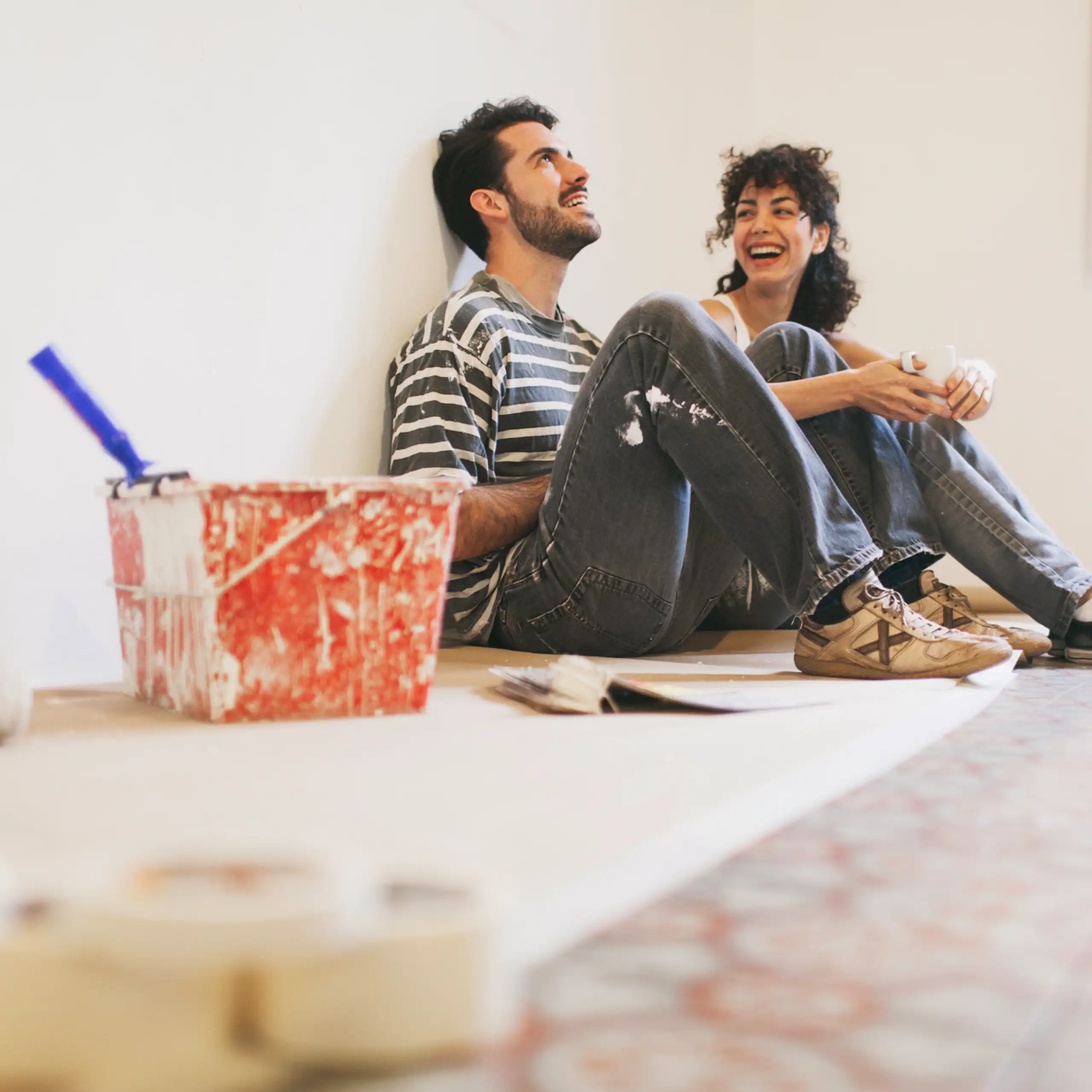 A couple rests between bouts of painting their apartment.
