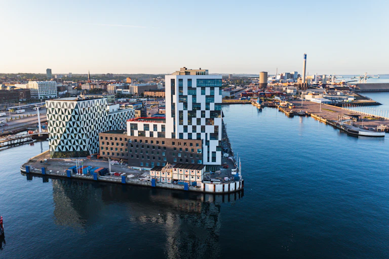 modern buildings in city district by clean blue river