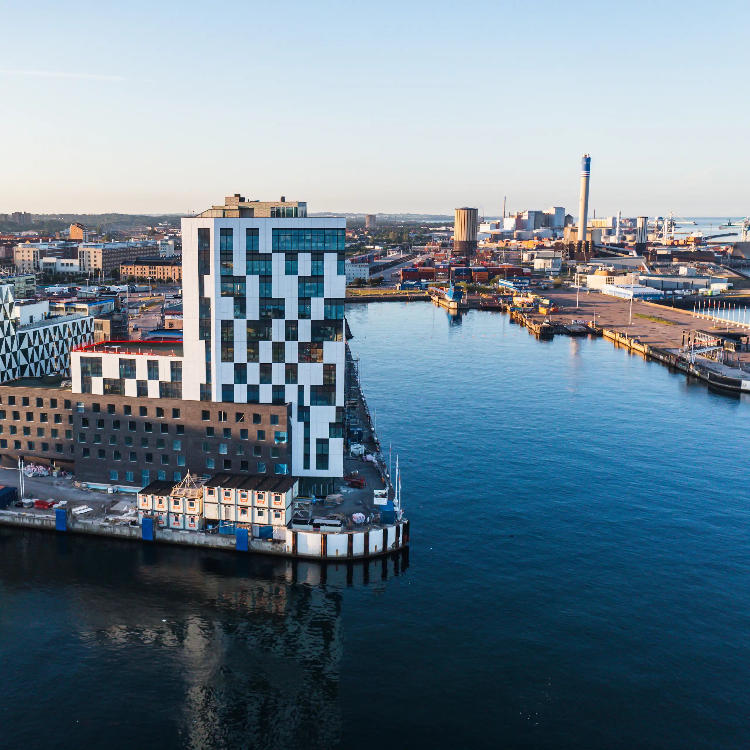 modern buildings in city district by clean blue river