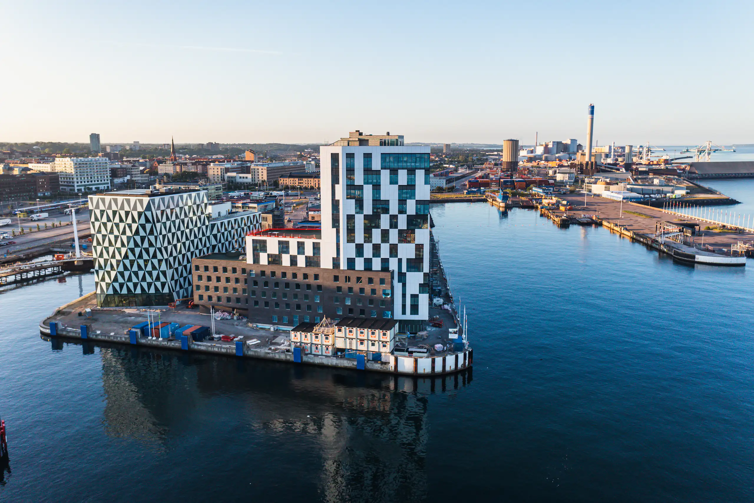 modern buildings in city district by clean blue river