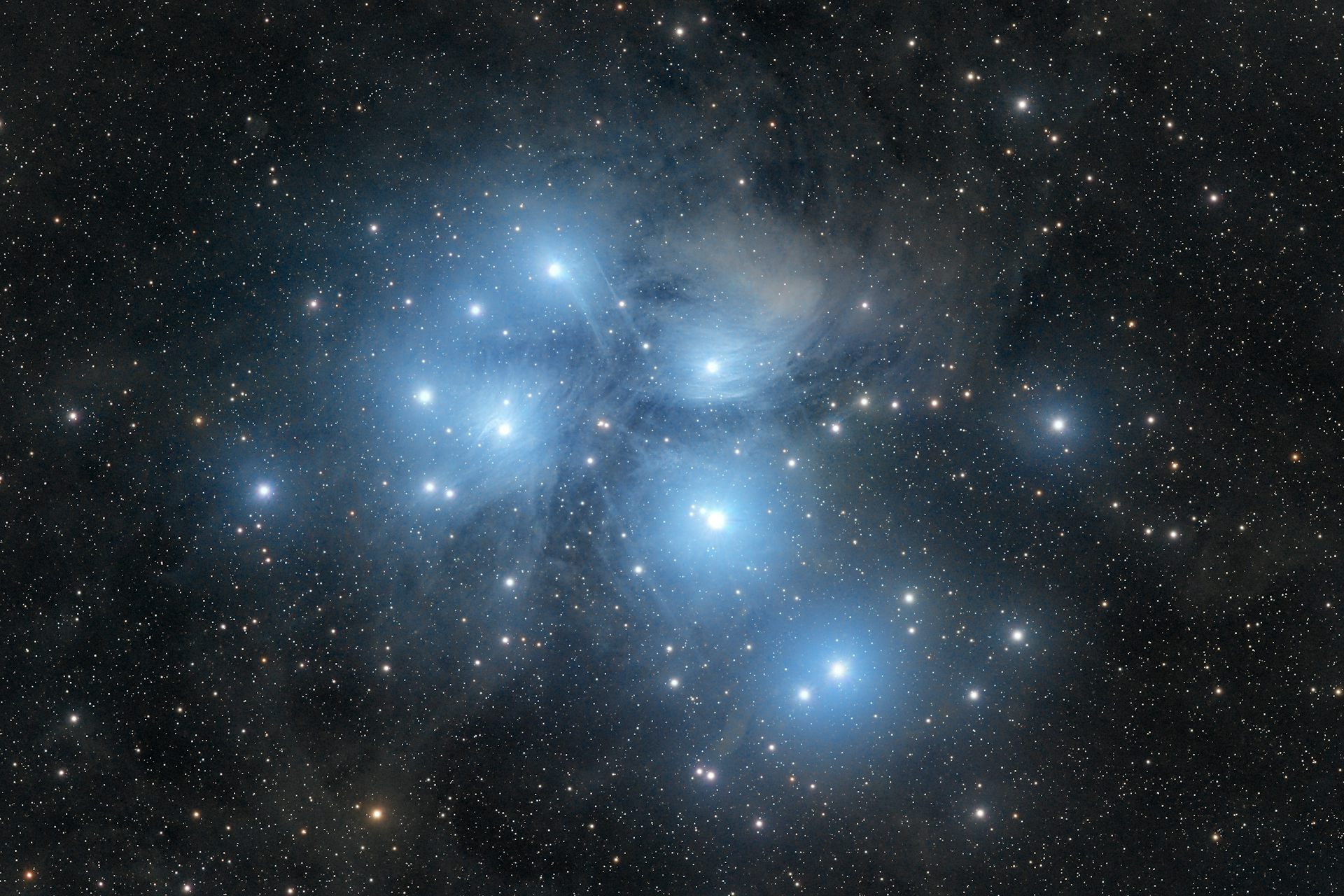 A bright open star cluster surrounded by reflection nebulosity