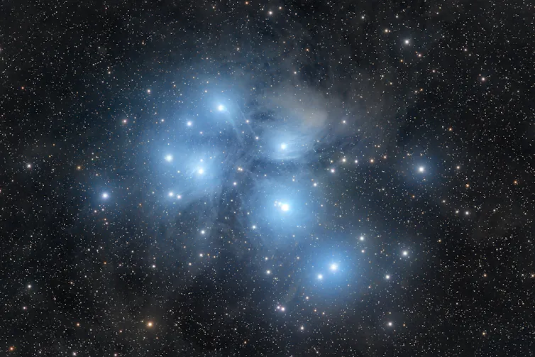 A bright open star cluster surrounded by reflection nebulosity