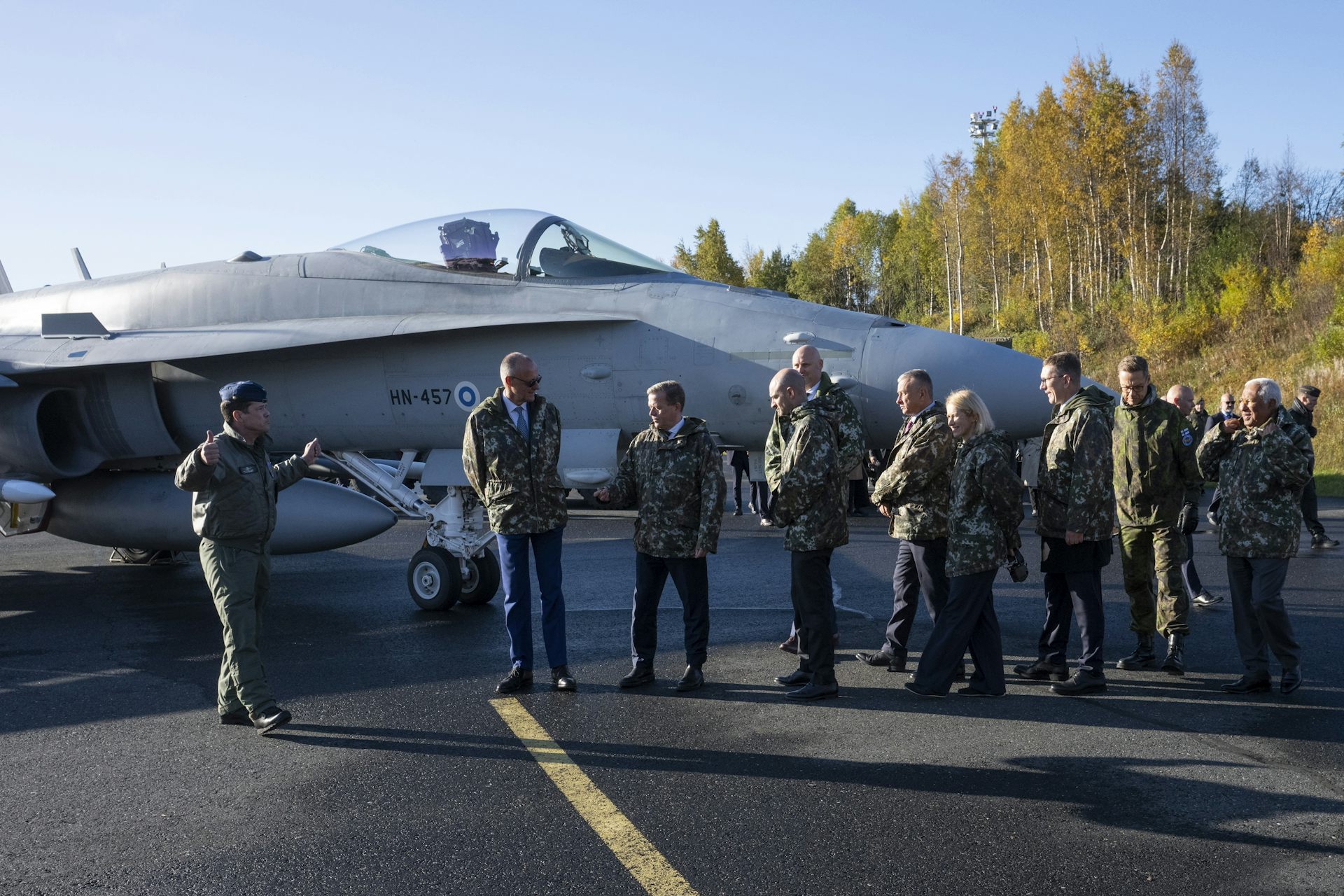 A group of EU leaders stand next to a fighter jet at an airbase in Rovaniemi.