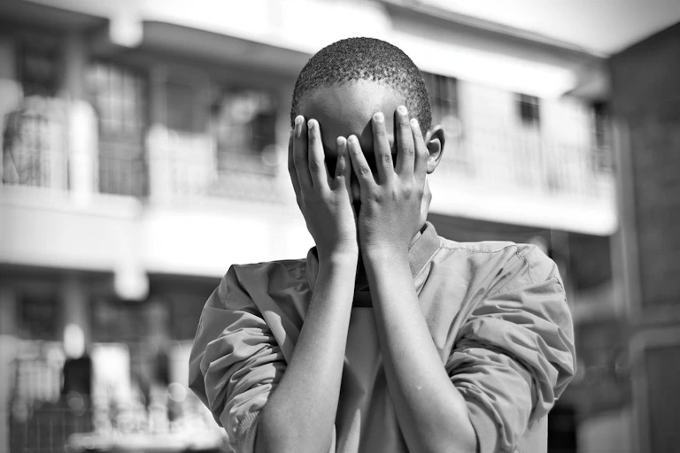 Child covering their face with their hands