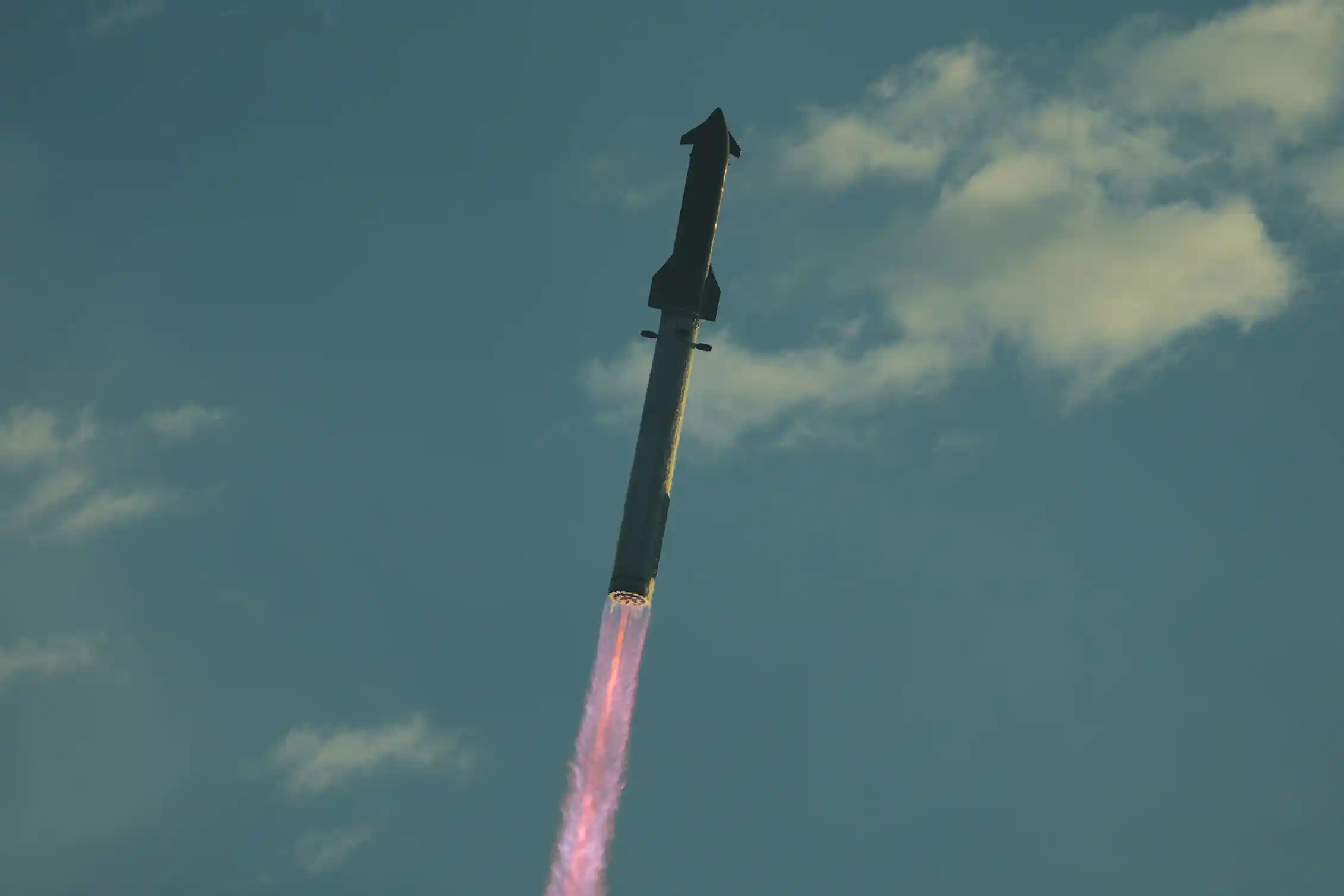 A rocket flying through the sky, propelled by a streak of flame