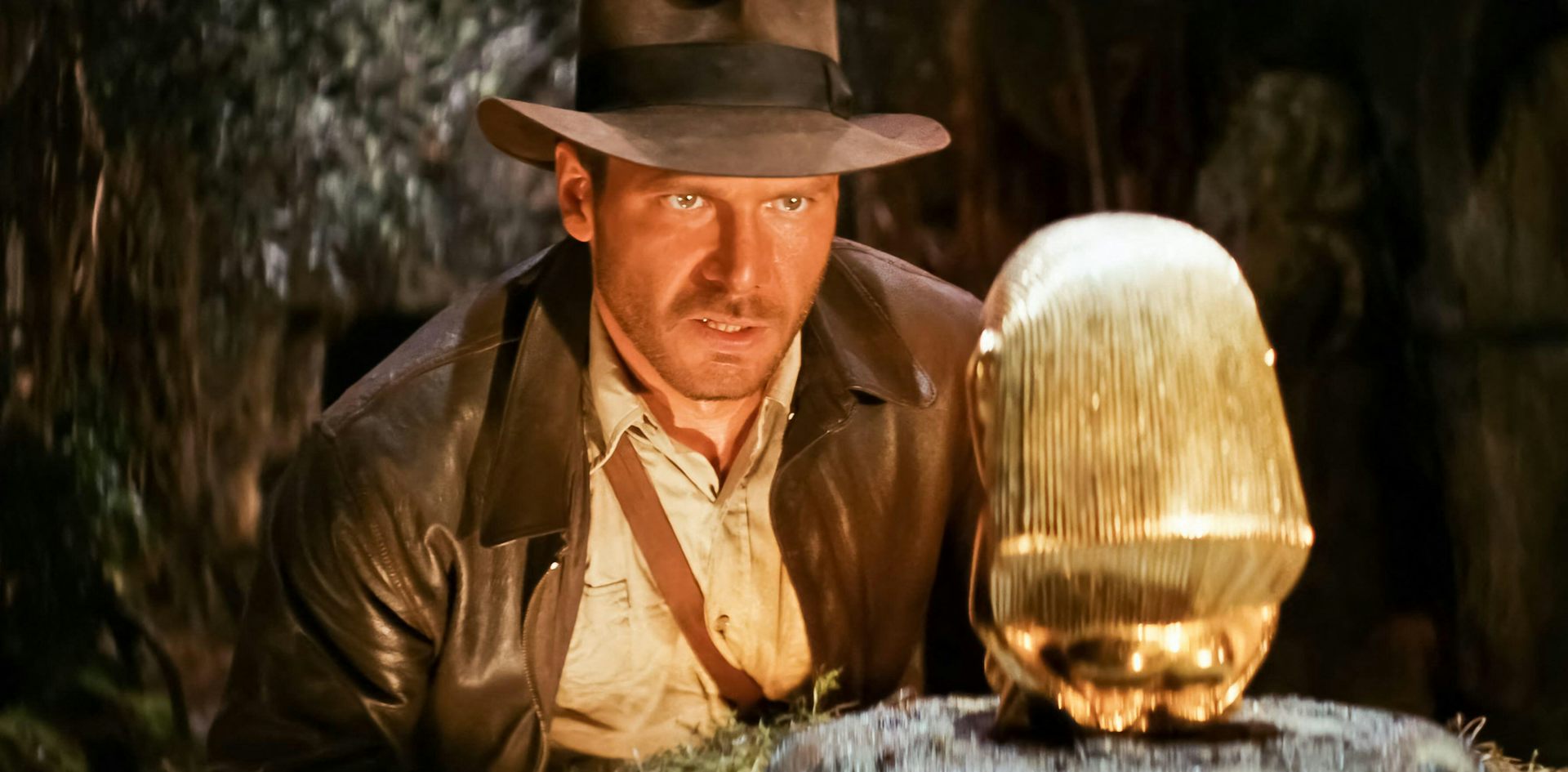 Indiana Jones observando um ícone de ouro em um templo.