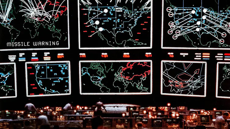 a dark room with a set of very large display screens