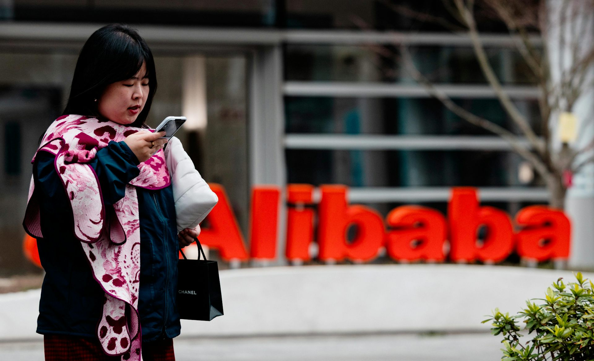 A woman stands in front of the Alibaba building in AI Park, Shanghai