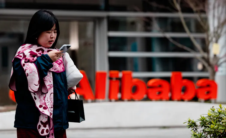 A woman stands in front of the Alibaba building in AI Park, Shanghai