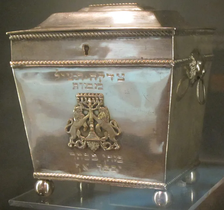 A large silver box with a design of two lions on either side of a candelabra.