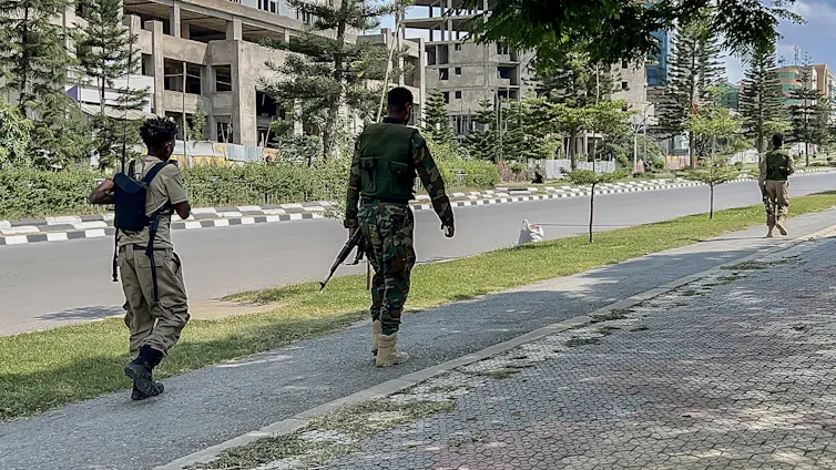 Men in army fatigues walk down the street