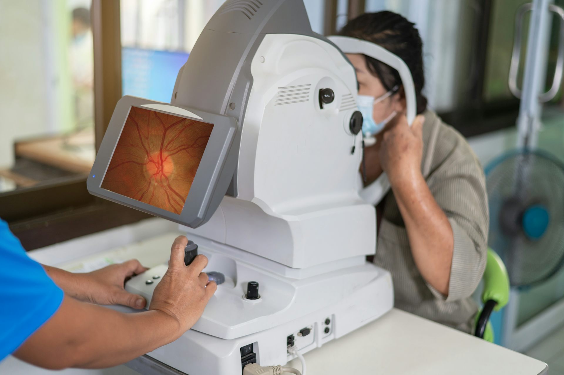 Ophthalmologist takes images of patient's retina using a refractometer eye test machine