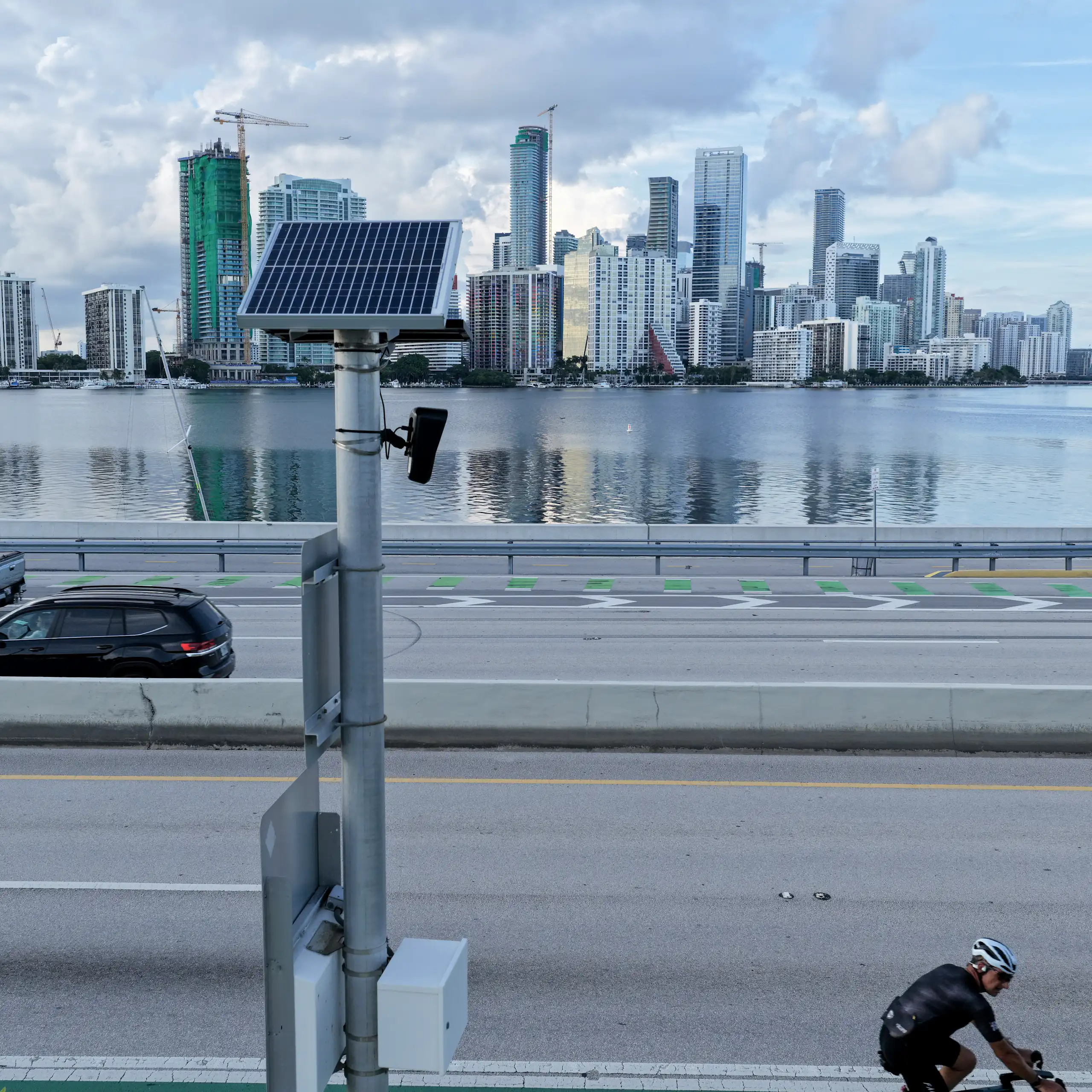 camera with solar panel aimed at a highway with the Miami skyline in the background