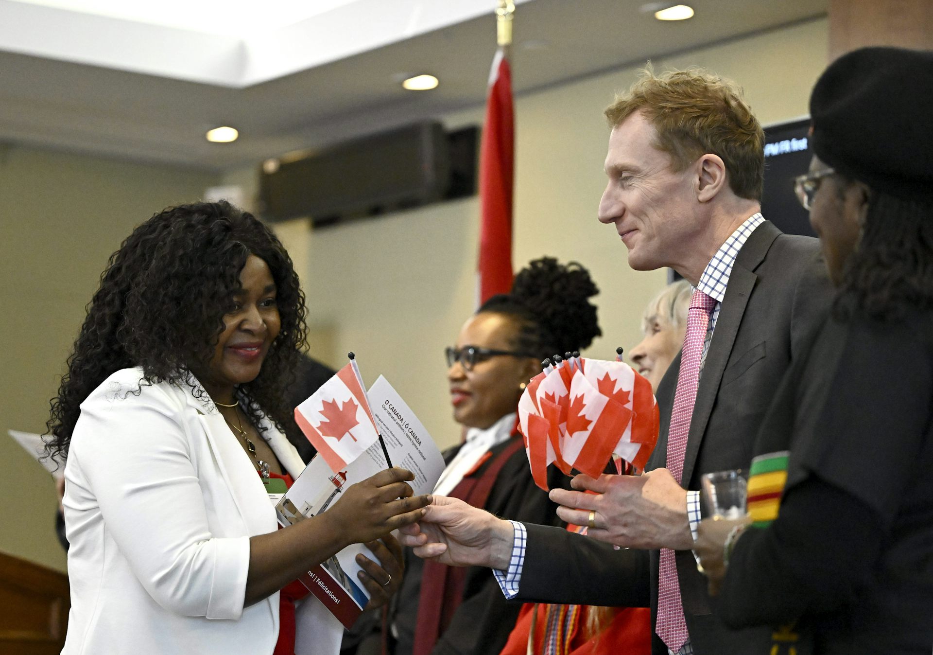 A woman takes a small flag from a woman who is distributing them.