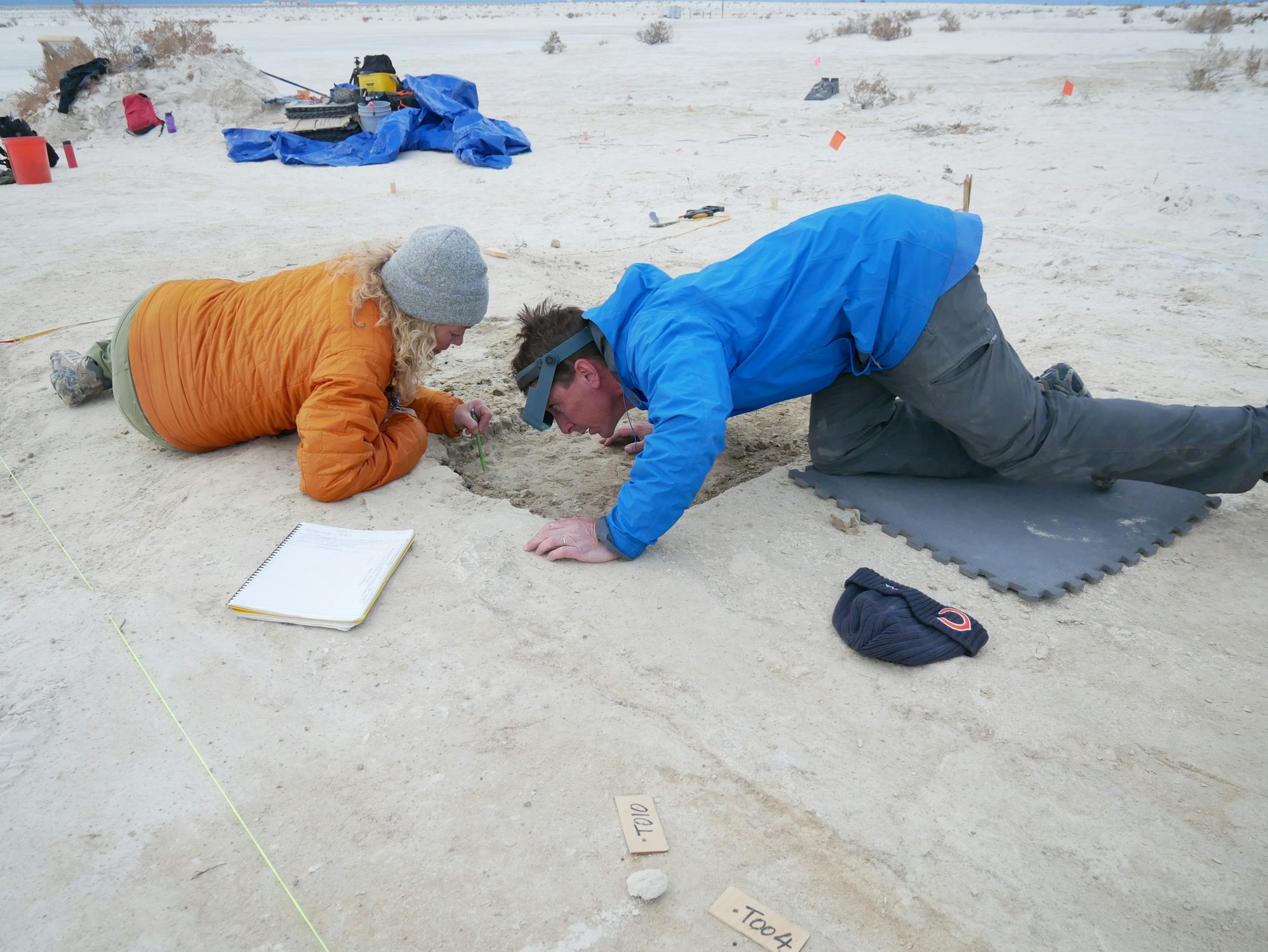 Archaeologists recording the placement of seeds found at the site.