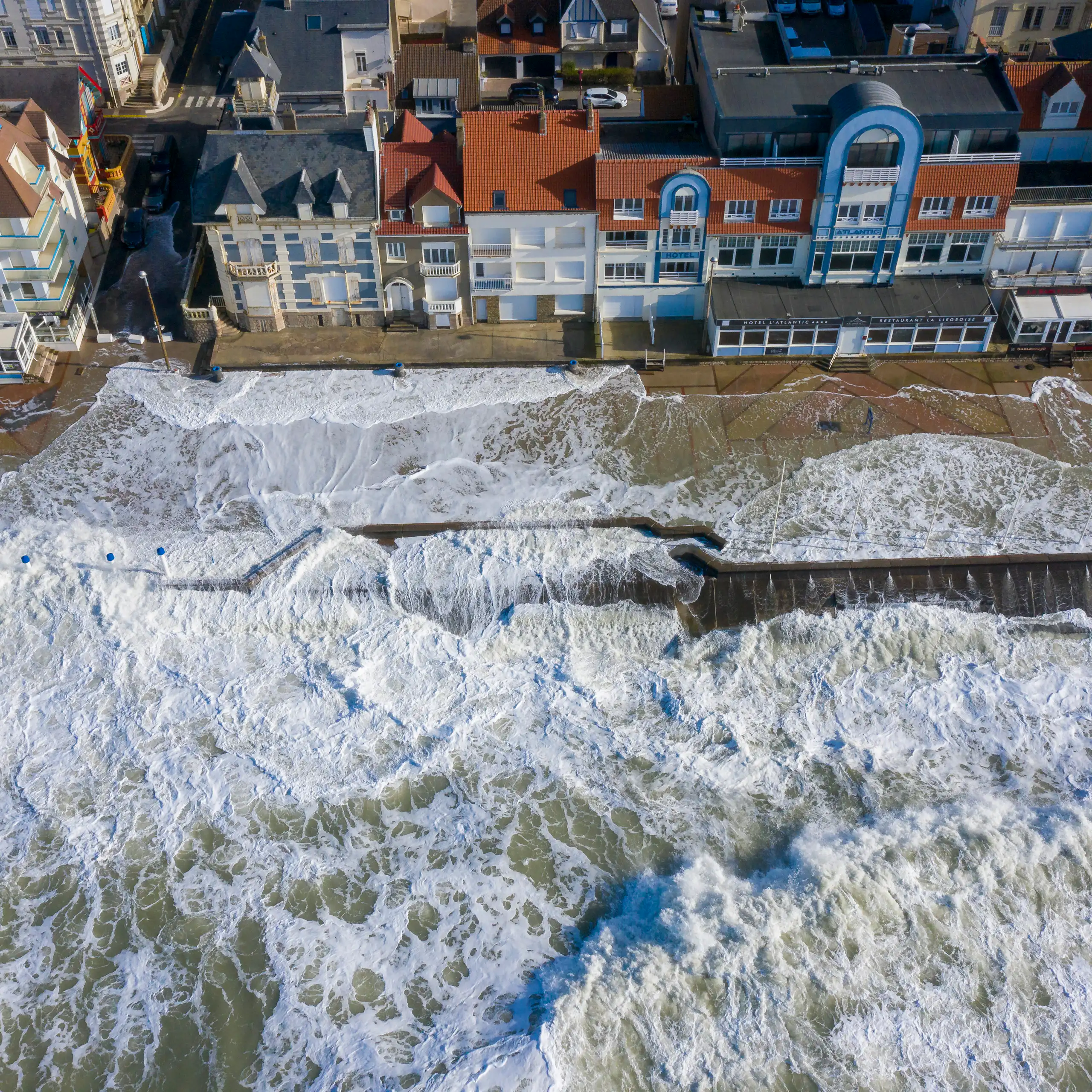 A city with high tides spilling over a seawall