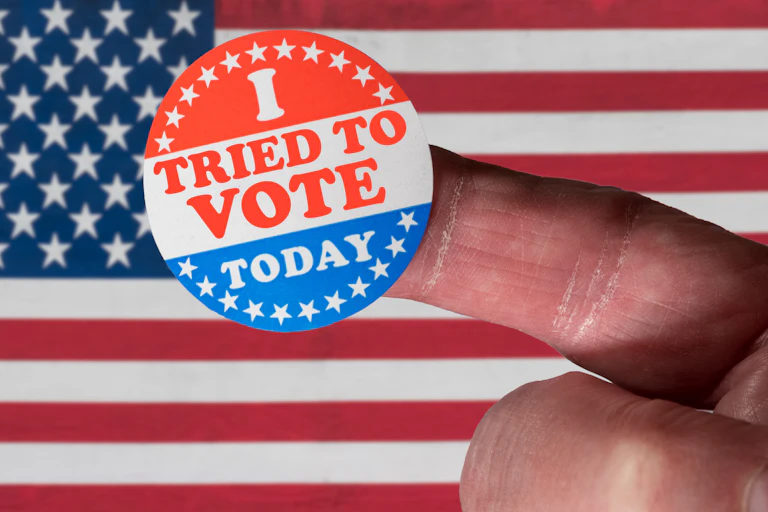 A finger with I TRIED TO VOTE TODAY sticker on it.