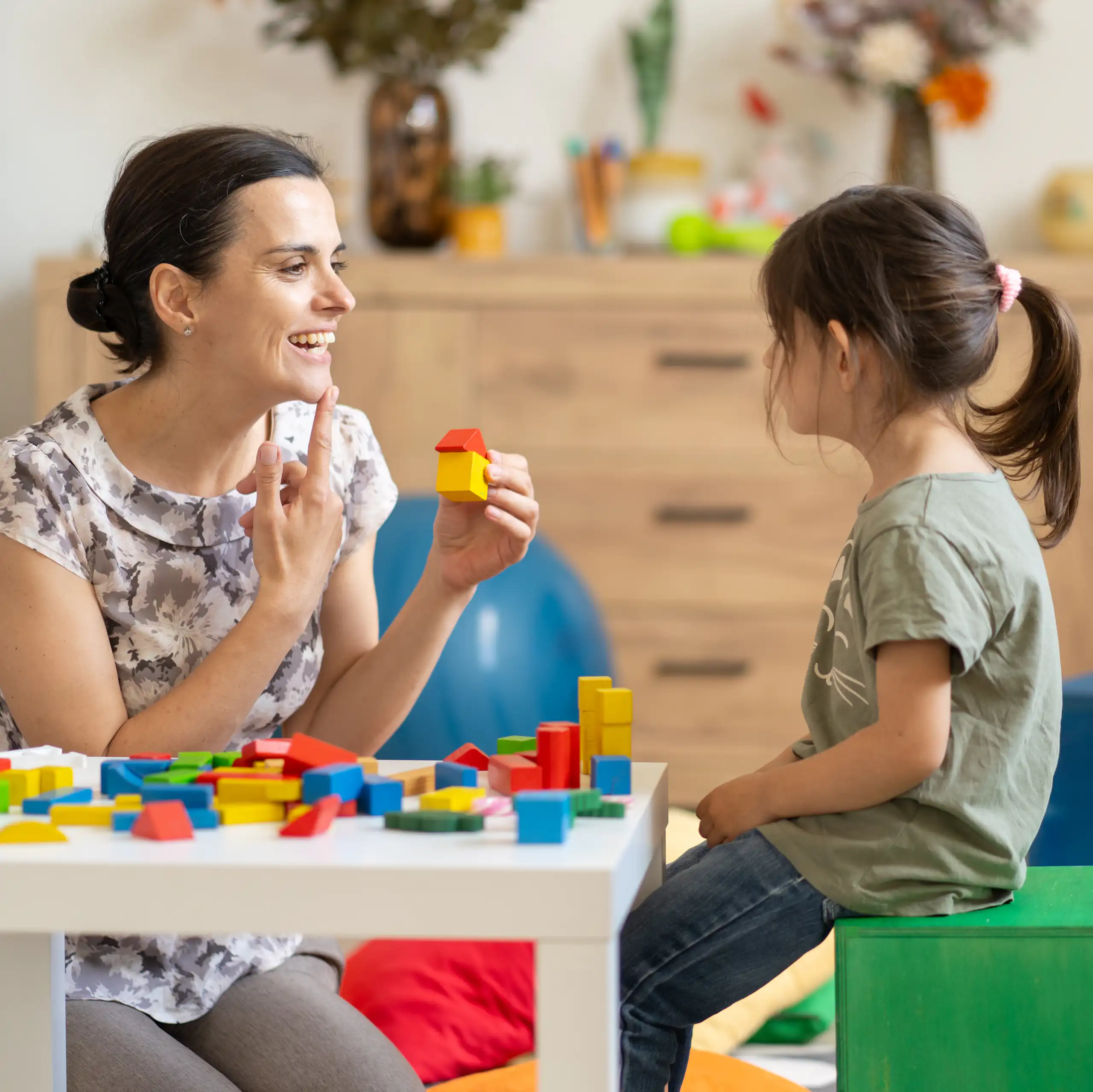 Speech pathologist talks to a young girl.