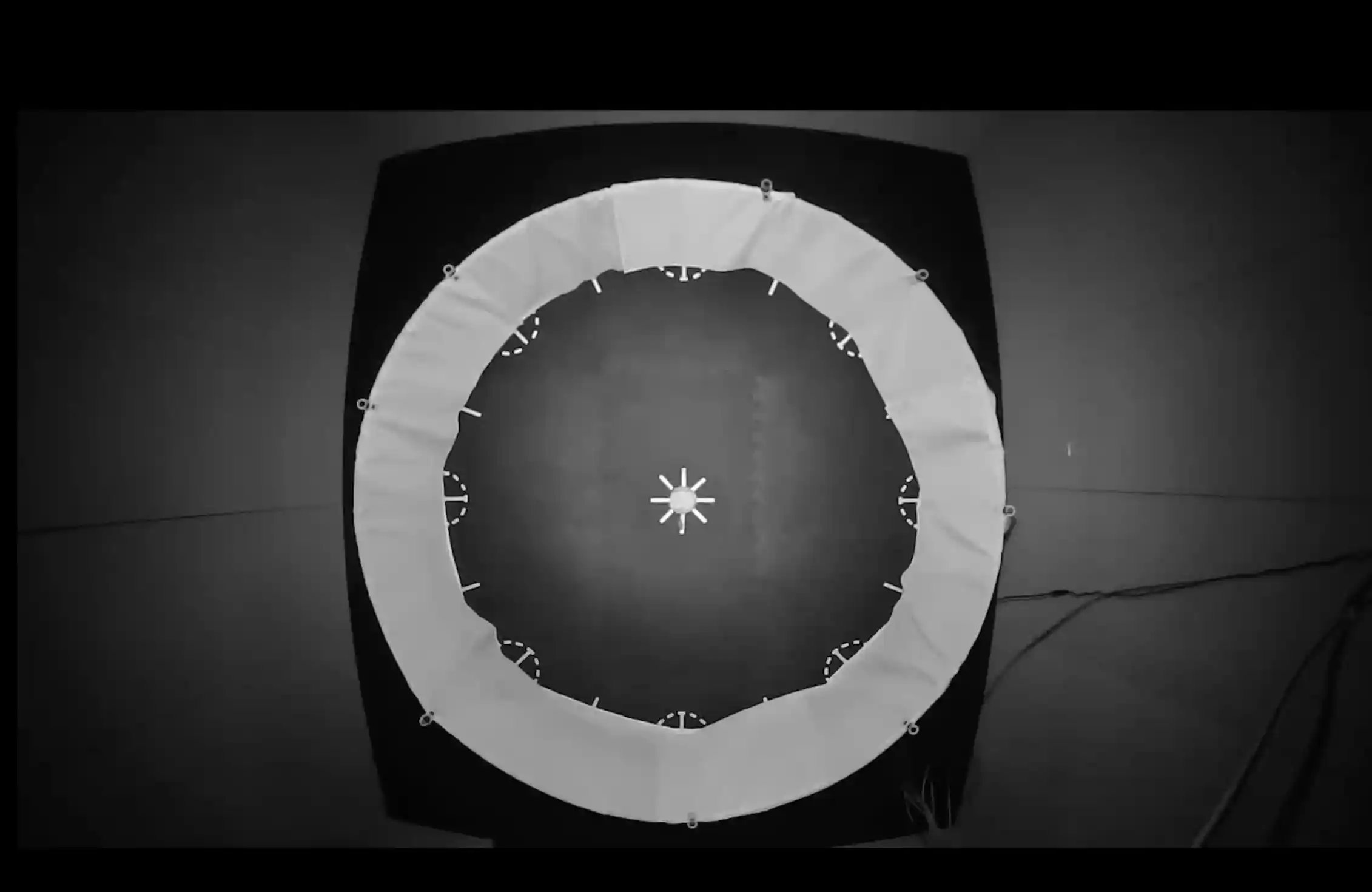 Black and white aerial view of a circular area with a white star in the middle