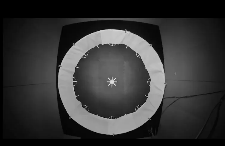 Black and white aerial view of a circular area with a white star in the middle