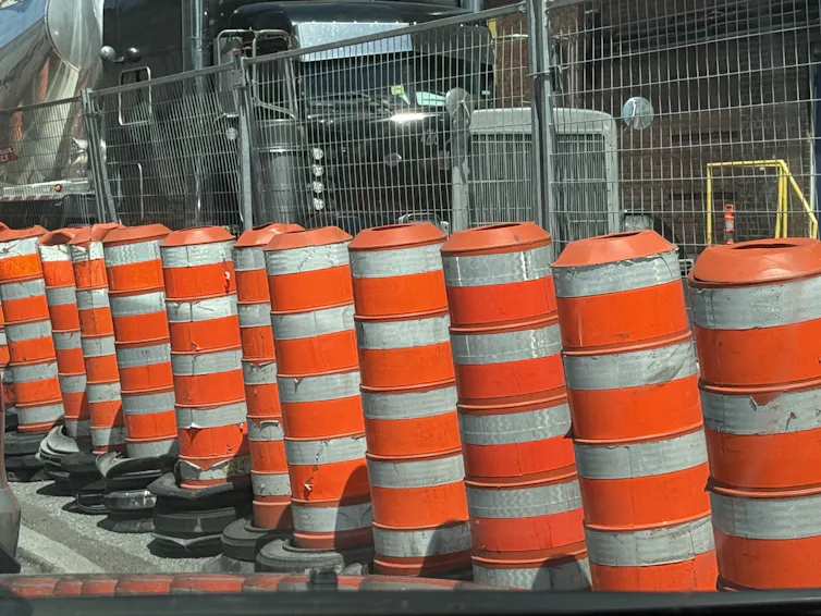 Des cônes orange bordent un chantier de construction