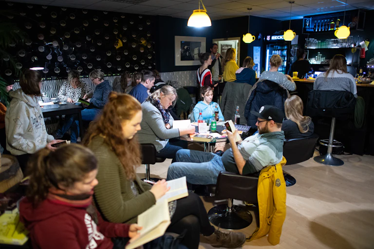People reading at tables in a bar