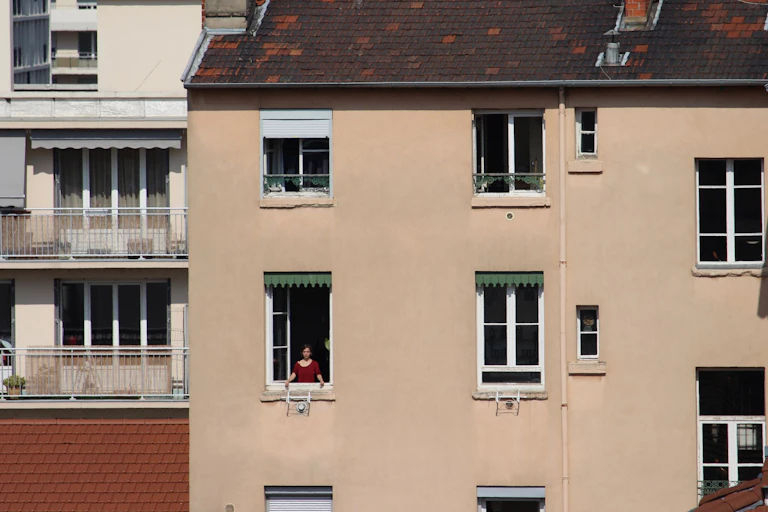 Une femme à sa fenêtre dans un immeuble à Lyon.