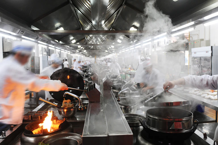 People wearing chefs outfits working in a kitchen