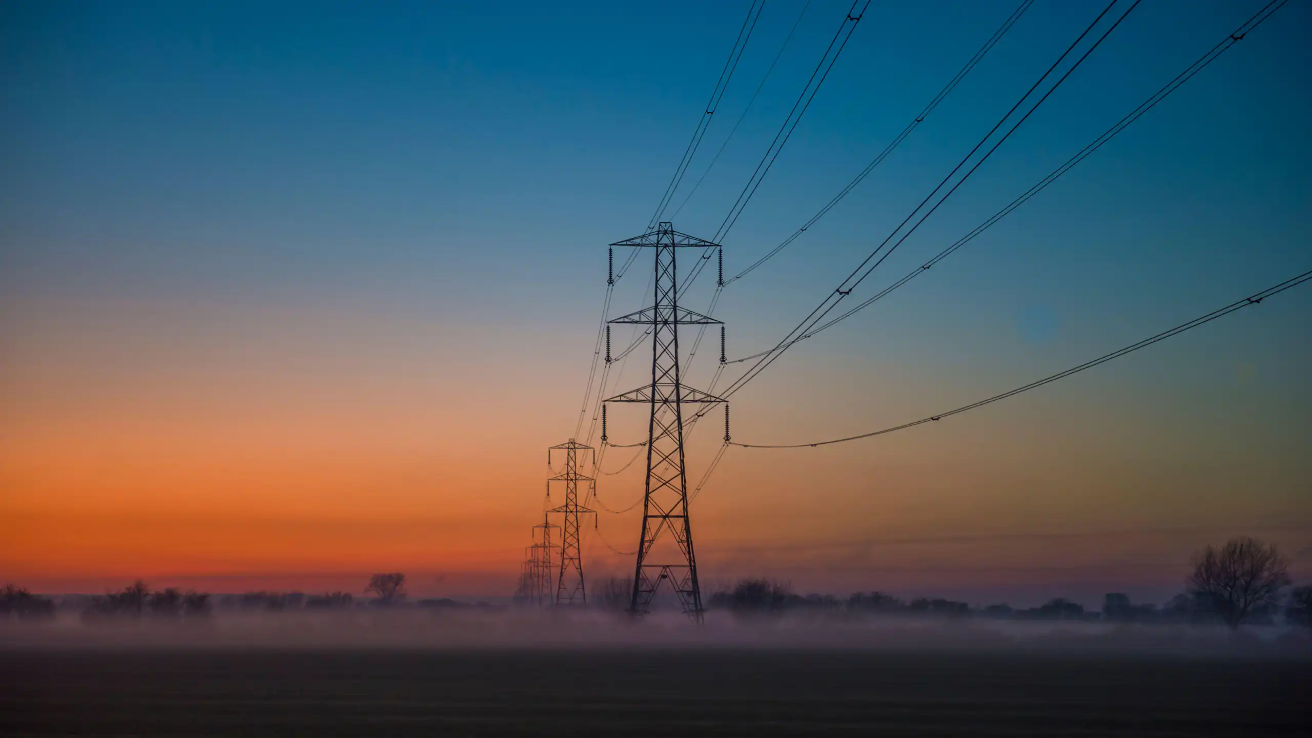Pylons in countryside at sunset